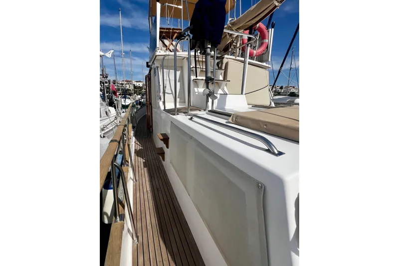 Apta Yacht Photos Pics 1989 Grand Banks 36 Classic yacht with wooden deck and railing in marina.