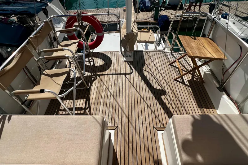 Apta Yacht Photos Pics 1989 Grand Banks 36 Classic yacht deck with chairs, table, and life preserver.