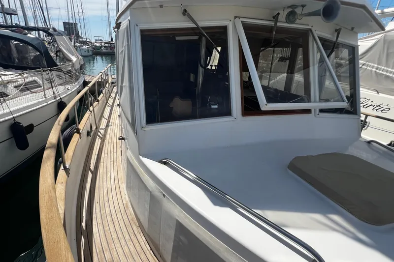 Apta Yacht Photos Pics 1989 Grand Banks 36 Classic yacht docked at marina, showcasing wooden deck and cabin windows.