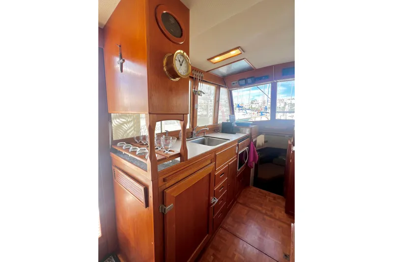 Apta Yacht Photos Pics Interior of 1989 Grand Banks 36 Classic yacht with wooden cabinetry and kitchen area.