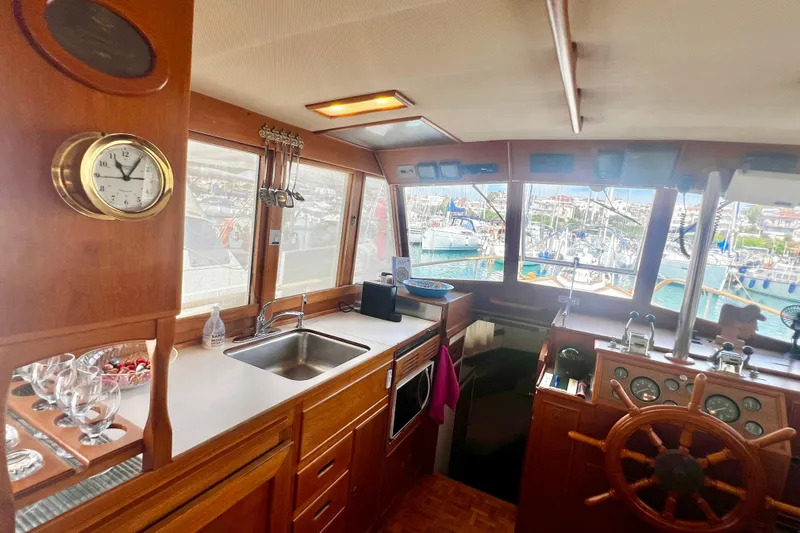 Apta Yacht Photos Pics Interior of 1989 Grand Banks 36 Classic yacht with wooden helm and kitchen area.