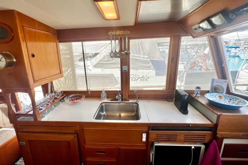 Apta Yacht Photos Pics 1989 Grand Banks 36 Classic yacht kitchen with wooden cabinetry, sink, and nautical decor.