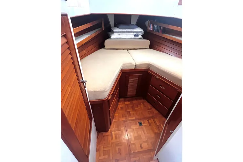 Apta Yacht Photos Pics 1989 Grand Banks 36 Classic cabin with wooden interior and cozy bedding.