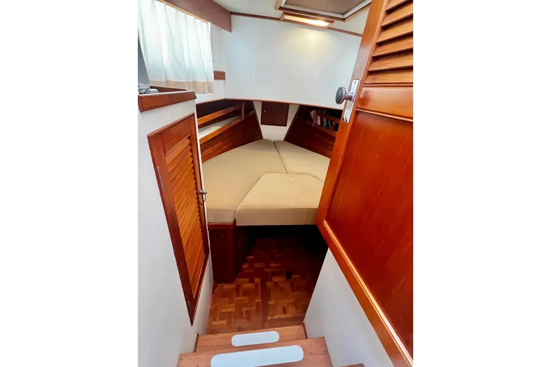 Apta Yacht Photos Pics Interior cabin of 1989 Grand Banks 36 Classic yacht with wooden finishes and cozy bed.