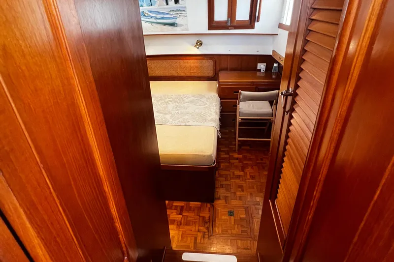 Apta Yacht Photos Pics 1989 Grand Banks 36 Classic cabin interior with wooden finish and cozy bed.