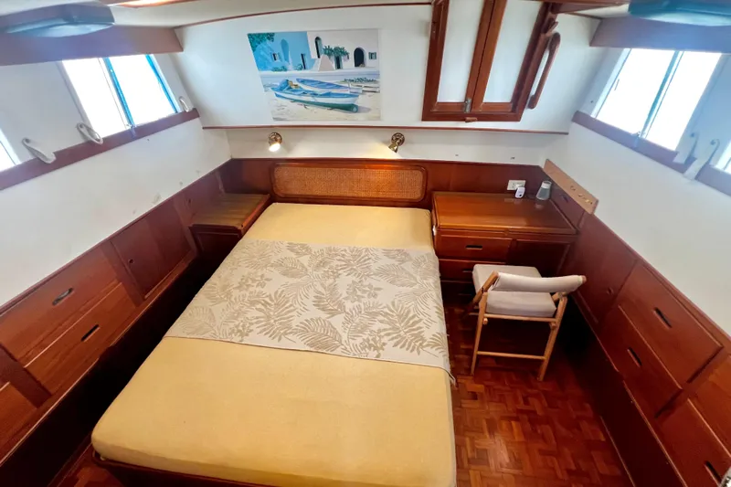 Apta Yacht Photos Pics Cozy cabin interior of 1989 Grand Banks 36 Classic yacht with bed and wooden furnishings.