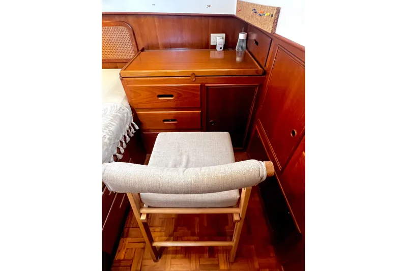 Apta Yacht Photos Pics Cozy wooden cabin interior with desk and cushioned chair on 1989 Grand Banks 36 Classic.
