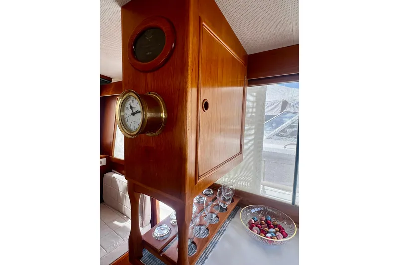 Apta Yacht Photos Pics Interior of 1989 Grand Banks 36 Classic yacht with wooden cabinetry and nautical clock.