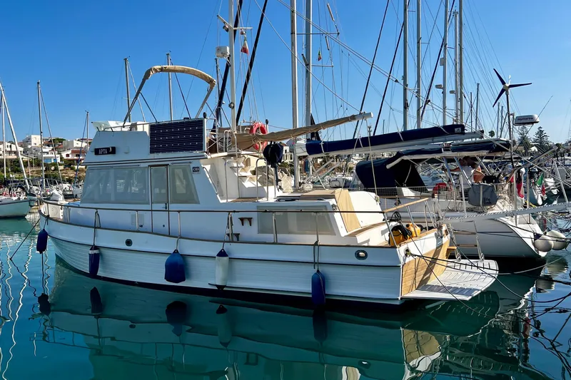 Apta Yacht Photos Pics 1989 Grand Banks 36 Classic yacht docked in a sunny marina, surrounded by sailboats.