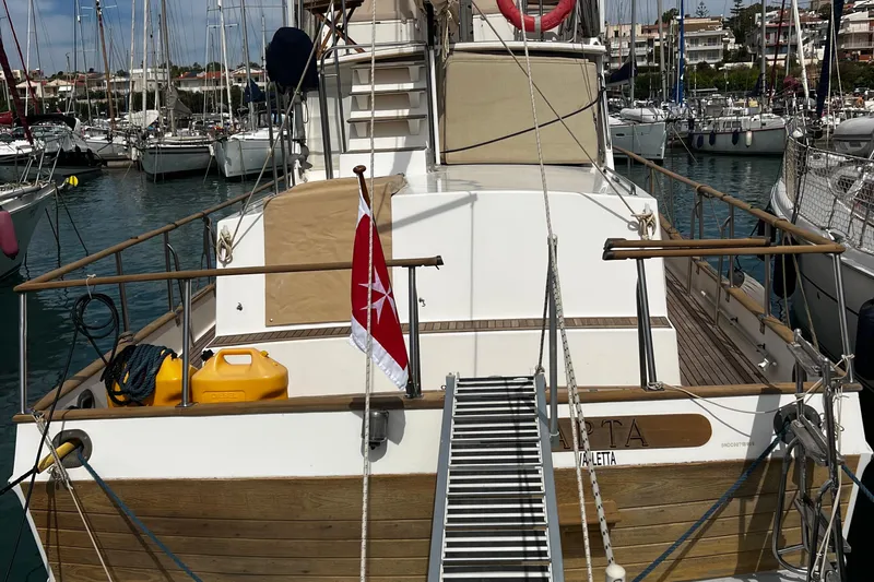 Apta Yacht Photos Pics 1989 Grand Banks 36 Classic yacht docked in a marina, featuring a wooden deck and flag.