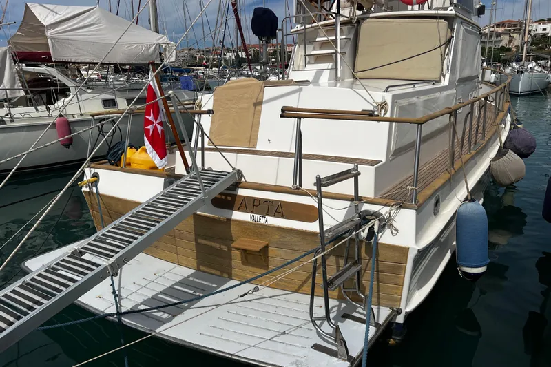 Apta Yacht Photos Pics 1989 Grand Banks 36 Classic yacht docked in marina with gangway and flag.