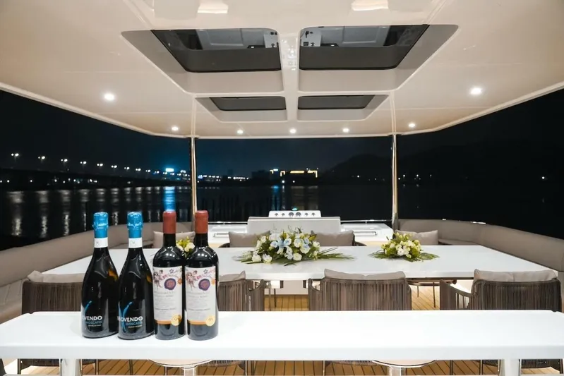  Yacht Photos Pics Luxurious 2025 GZ Yachts TY560 deck with elegant dining setup and wine bottles at night.