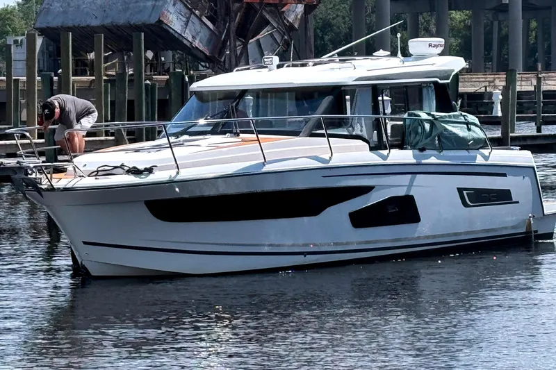 Bohemian Yacht Photos Pics 2021 Jeanneau NC Weekender 1095 boat docked at marina with person on deck.