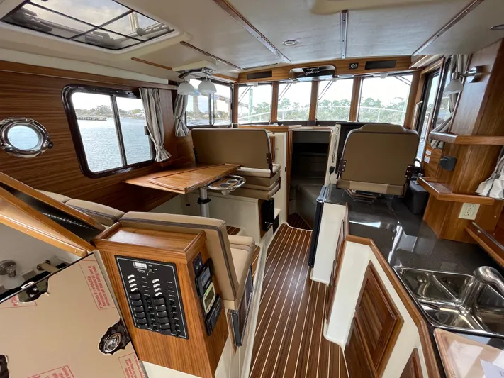  Yacht Photos Pics 2023 Ranger Tugs R-31 CB interior with wood accents and panoramic windows.
