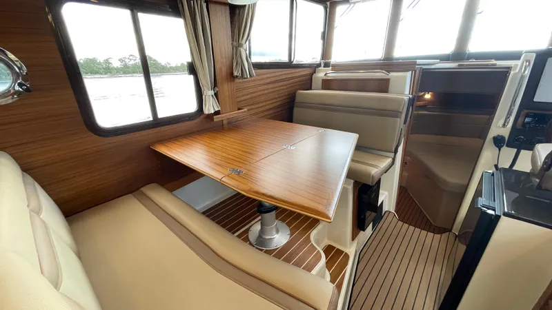  Yacht Photos Pics 2023 Ranger Tugs R-31 CB interior with wood accents and beige seating.