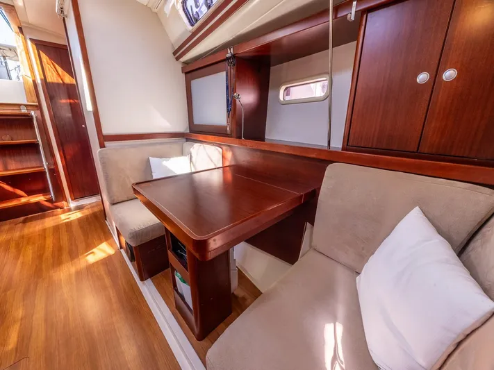  Yacht Photos Pics Interior of 2008 Hanse 400 yacht with wooden table and cushioned seating.