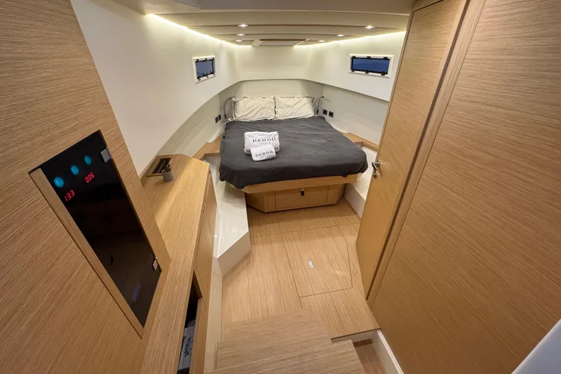  Yacht Photos Pics Luxurious cabin interior of 2025 Pardo Yachts P38, featuring modern wood finishes and cozy bedding.