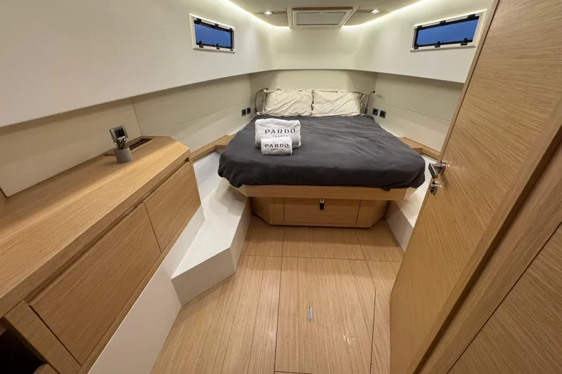 Yacht Photos Pics Luxurious cabin interior of 2025 Pardo Yachts P38, featuring modern wood finishes and cozy bedding.