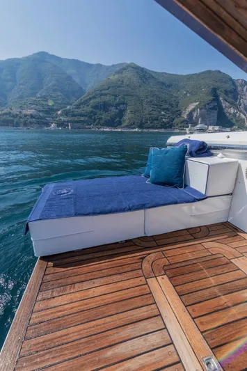  Yacht Photos Pics 1996 Uniesse 48 Open yacht with sun deck, scenic mountain backdrop, and clear blue water.