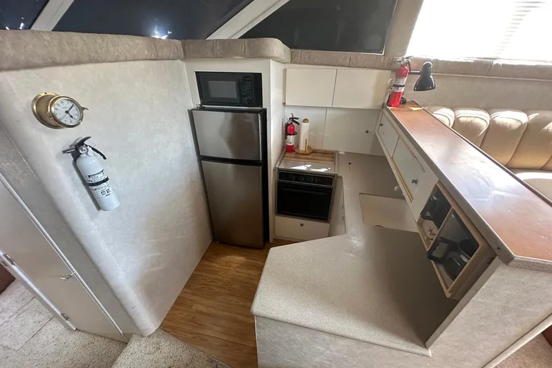 Dunac's Minni Conn III Yacht Photos Pics 1997 Silverton 422 Motor Yacht kitchen with appliances, fire extinguisher, and clock.