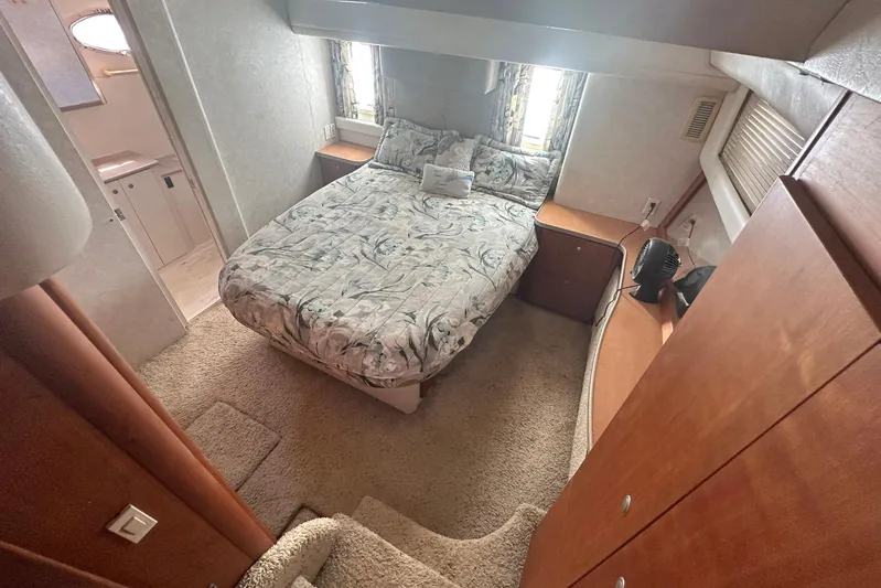 Dunac's Minni Conn III Yacht Photos Pics Cozy bedroom in 1997 Silverton 422 Motor Yacht with plush bedding and wooden cabinetry.