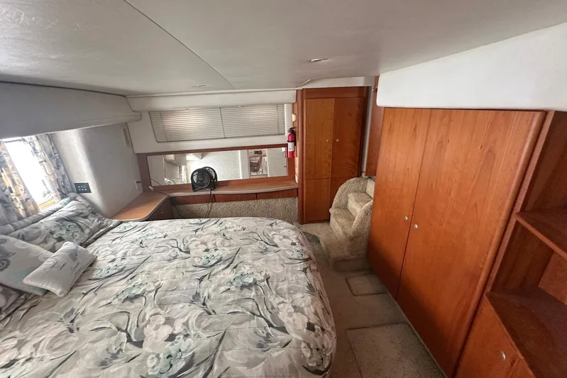 Dunac's Minni Conn III Yacht Photos Pics Luxurious 1997 Silverton 422 Motor Yacht bedroom with floral bedding and wooden cabinetry.