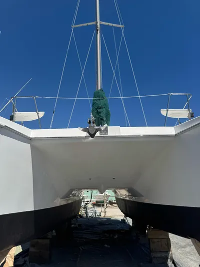 Shamrock Yacht Photos Pics 2002 Endeavour 44 Sail Catamaran on land, under clear blue sky.
