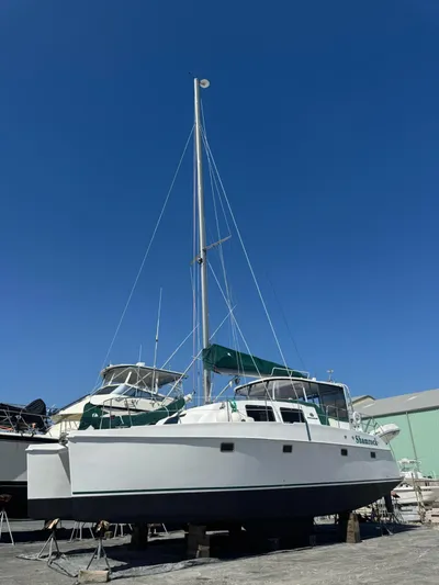 Shamrock Yacht Photos Pics 2002 Endeavour 44 Sail Catamaran on dry dock under clear blue sky.