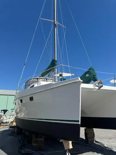 Shamrock Yacht Photos Pics 2002 Endeavour 44 Sail Catamaran on dry dock under clear blue sky.