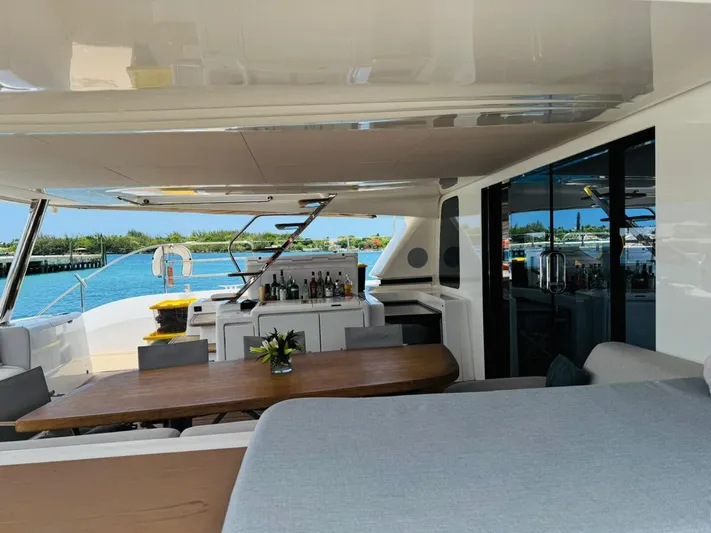  Yacht Photos Pics Luxurious Lagoon 65 yacht interior, featuring a dining area and bar with ocean view, 2024 model.
