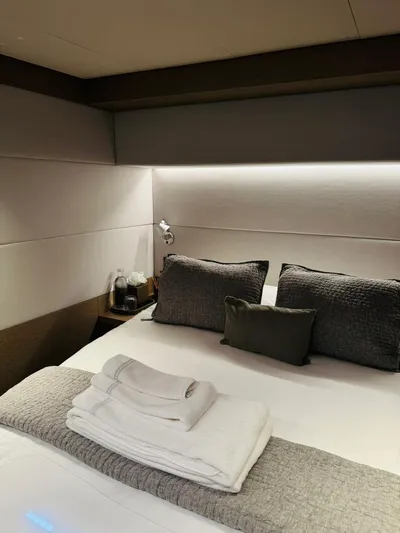  Yacht Photos Pics Luxurious bedroom interior of 2024 Lagoon 65 yacht with plush bedding and ambient lighting.