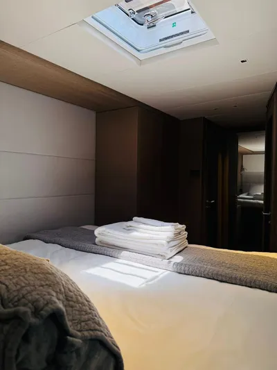  Yacht Photos Pics Luxurious cabin interior of 2024 Lagoon 65 yacht with skylight and neatly arranged linens.