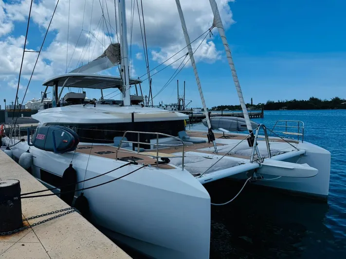  Yacht Photos Pics 2024 Lagoon 65 catamaran docked at marina under clear blue sky.