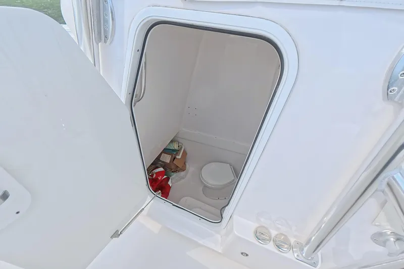  Yacht Photos Pics 2019 SeaHunter 33 Tournament boat interior with open storage compartment and visible toilet.