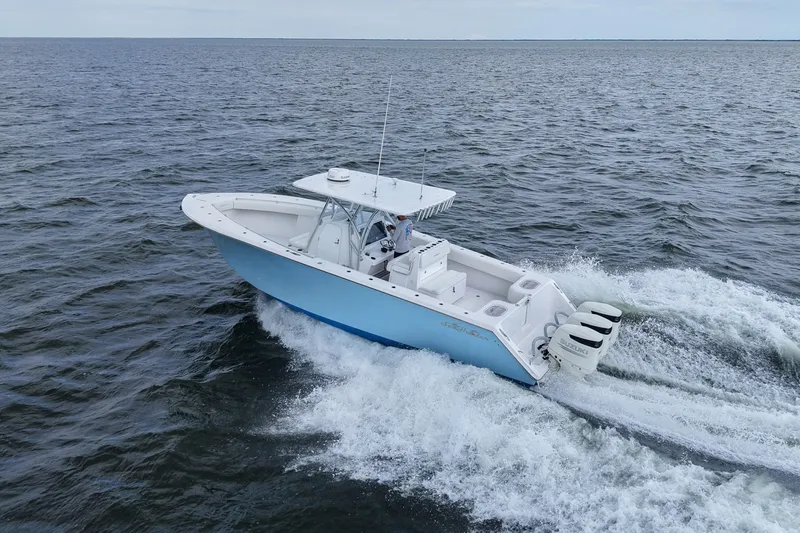 Yacht Photos Pics 2019 SeaHunter 33 Tournament boat cruising on open water, featuring triple outboard engines.