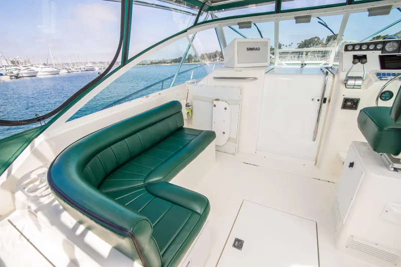 Dos Panchos Yacht Photos Pics 1997 Cabo 35 Express boat interior with green seating, overlooking marina.