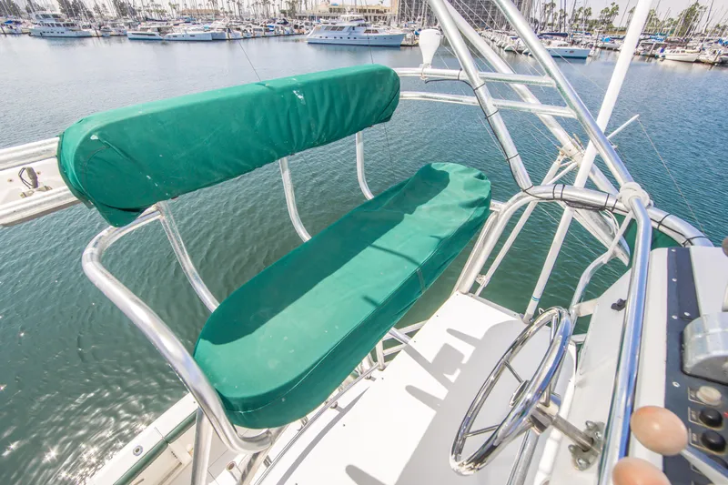 Dos Panchos Yacht Photos Pics 1997 Cabo 35 Express boat helm with green cushioned seating, overlooking marina.