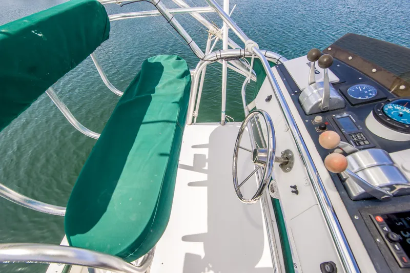 Dos Panchos Yacht Photos Pics Cockpit of 1997 Cabo 35 Express boat with green seating and steering wheel.