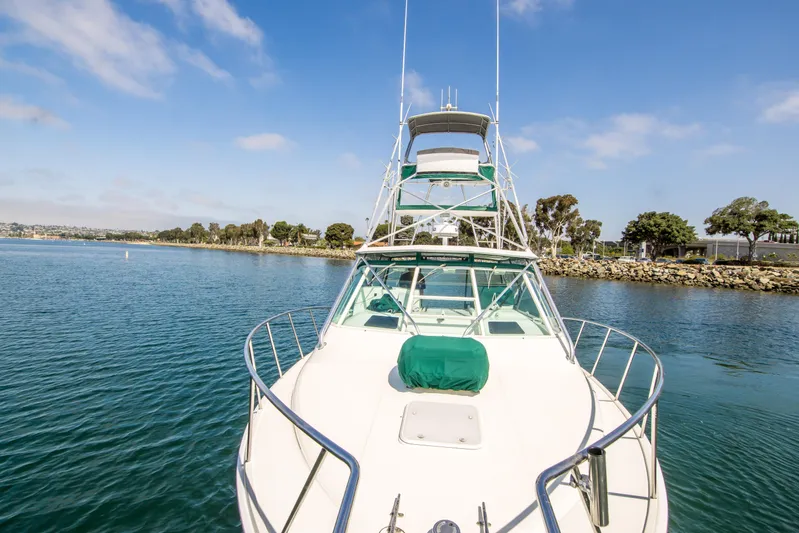 Dos Panchos Yacht Photos Pics 1997 Cabo 35 Express boat on calm water with clear sky and shoreline.