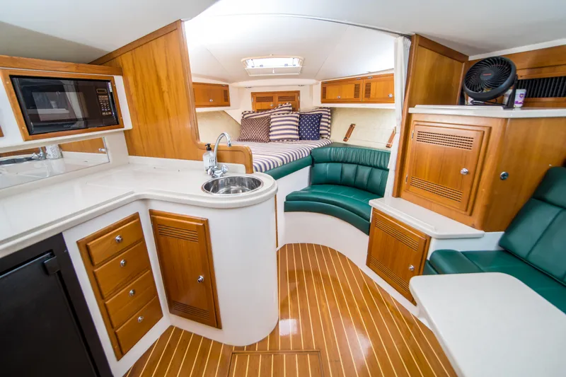 Dos Panchos Yacht Photos Pics Interior of a 1997 Cabo 35 Express yacht with kitchen and seating area.