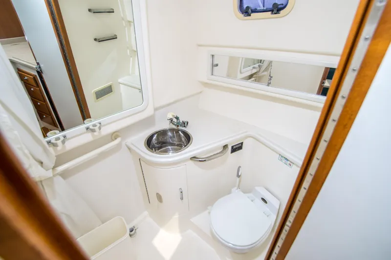 Dos Panchos Yacht Photos Pics 1997 Cabo 35 Express boat bathroom with sink, toilet, and mirror.
