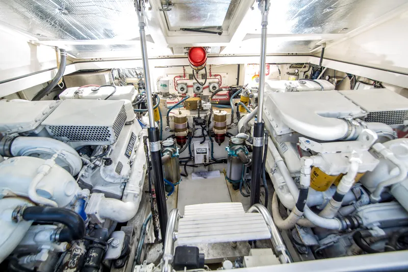 Dos Panchos Yacht Photos Pics Engine room of a 1997 Cabo 35 Express boat, showcasing dual engines and mechanical components.