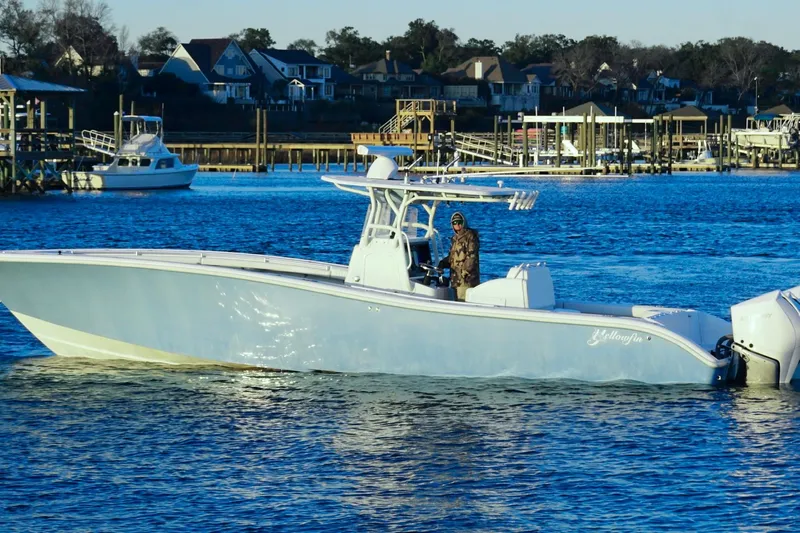  Yacht Photos Pics 2007 Yellowfin 36 Offshore boat cruising on a calm waterfront with houses in the background.