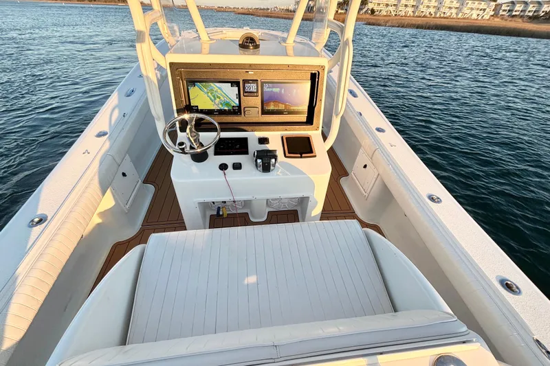  Yacht Photos Pics 2007 Yellowfin 36 Offshore boat cockpit with navigation screens and steering wheel on calm water.