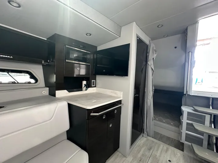  Yacht Photos Pics Interior of 2021 Formula 400 Super Sport Crossover, featuring modern kitchen and cozy sleeping area.