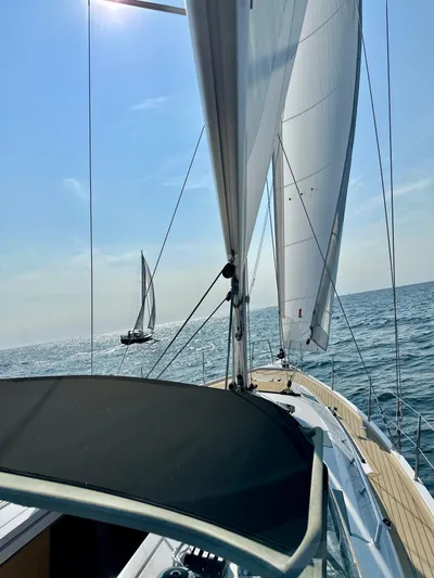 Hard Loaded Yacht Photos Pics 2024 Elan Impression 43 sailing on open sea under clear blue sky.
