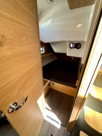 Hard Loaded Yacht Photos Pics 2024 Elan Impression 43 yacht cabin interior with wooden finish and cozy sleeping area.