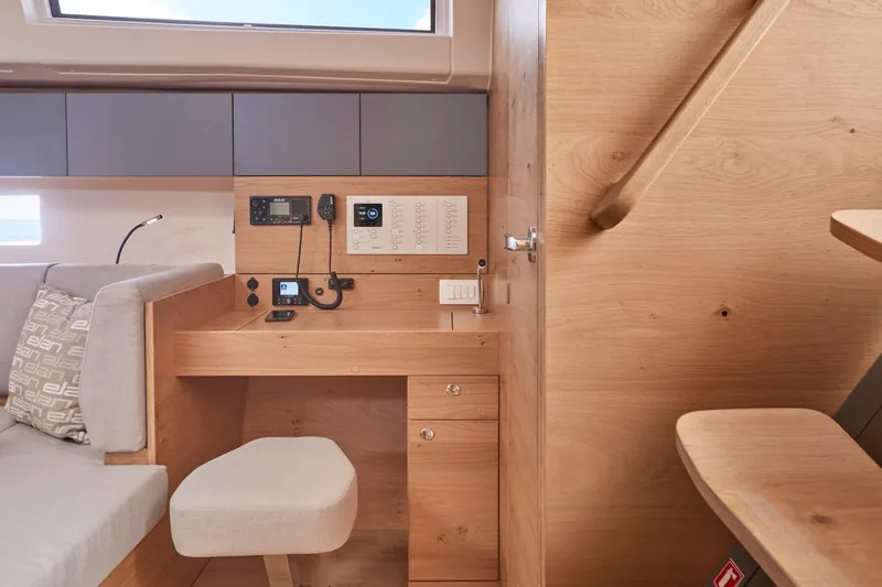 Hard Loaded Yacht Photos Pics 2024 Elan Impression 43 yacht interior with navigation station and wooden finish.