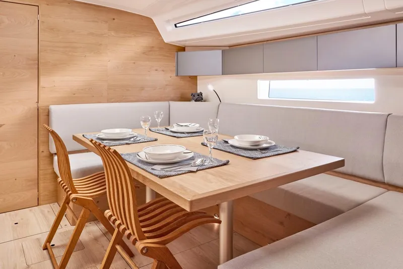 Hard Loaded Yacht Photos Pics Modern dining area inside 2024 Elan Impression 43 yacht with wooden table and chairs.