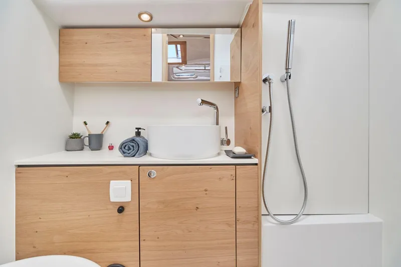 Hard Loaded Yacht Photos Pics Modern bathroom in 2024 Elan Impression 43 yacht with wooden cabinets and sleek fixtures.